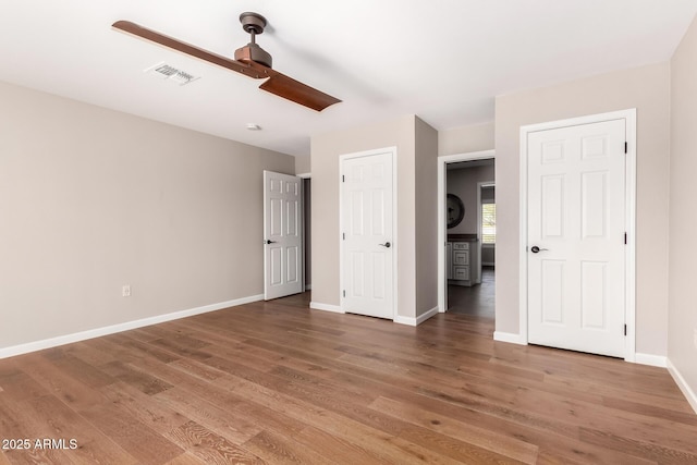 unfurnished bedroom with light wood-style floors, baseboards, visible vents, and ceiling fan