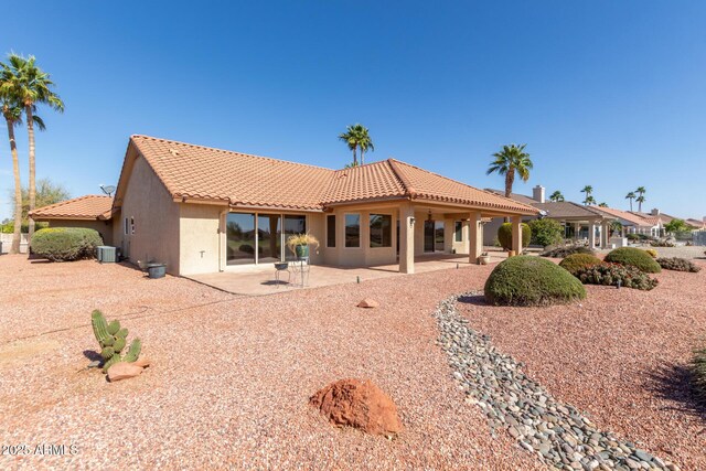 back of property featuring cooling unit, a patio area, a tile roof, and stucco siding