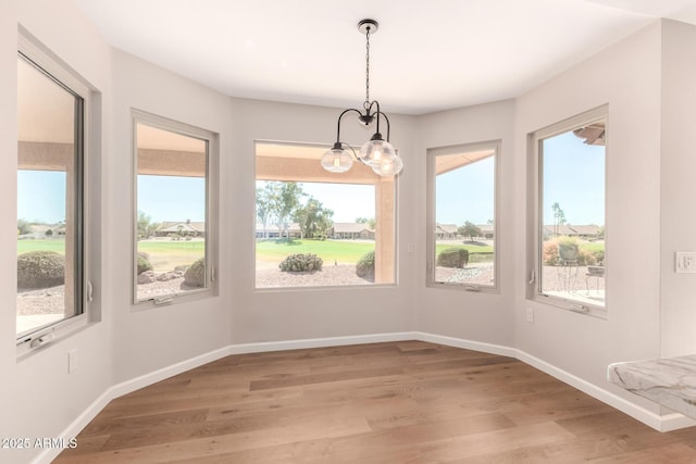 unfurnished dining area with light wood-style floors and baseboards