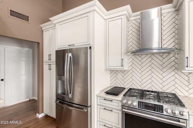 kitchen featuring stainless steel appliances, visible vents, wall chimney exhaust hood, and tasteful backsplash