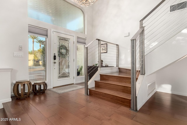 entryway featuring wood-type flooring and a high ceiling