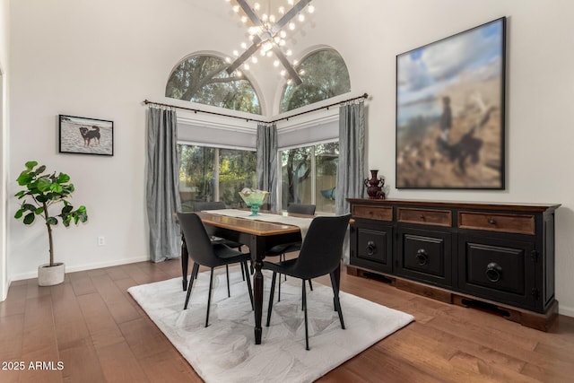 dining room featuring high vaulted ceiling, dark hardwood / wood-style floors, and a chandelier