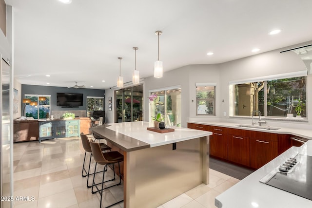 kitchen featuring sink, hanging light fixtures, a kitchen breakfast bar, a spacious island, and light tile patterned flooring