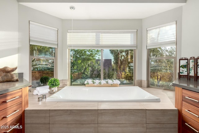 bathroom featuring vanity and a relaxing tiled tub