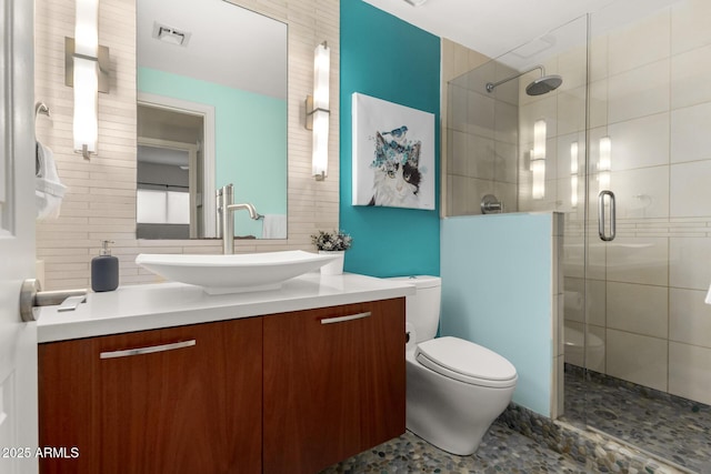 bathroom featuring a shower with door, vanity, tasteful backsplash, and toilet