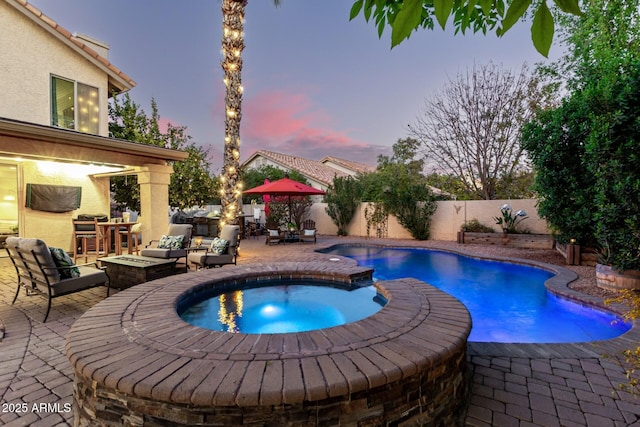 view of swimming pool featuring an in ground hot tub and a patio