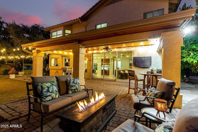 patio terrace at dusk featuring an outdoor living space with a fire pit