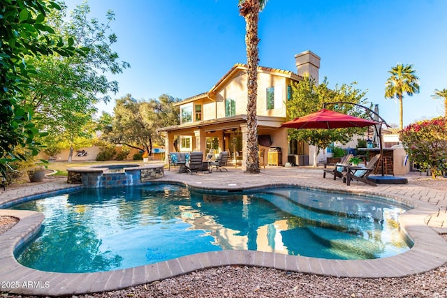 view of pool with a bar, area for grilling, an in ground hot tub, and a patio area