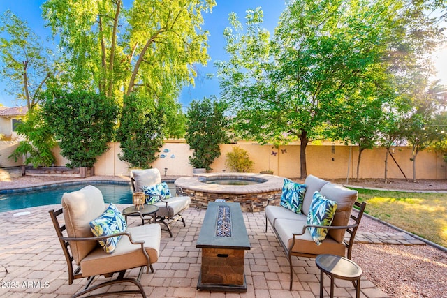 view of patio / terrace with a swimming pool with hot tub and an outdoor living space with a fire pit