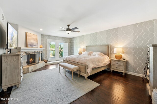 7214 E Royal Palm Rd, Scottsdale, AZ 85258 - bedroom featuring wallpapered walls, a warm lit fireplace, baseboards, hardwood / wood-style floors, and an accent wall