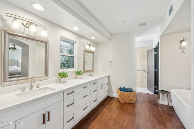 7214 E Royal Palm Rd, Scottsdale, AZ 85258 - bathroom featuring ensuite bath, double vanity, a soaking tub, a ceiling fan, and wood finished floors