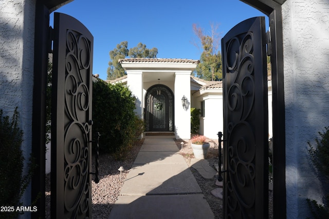 7214 E Royal Palm Rd, Scottsdale, AZ 85258 - doorway to property with a gate, stucco siding, and a tiled roof