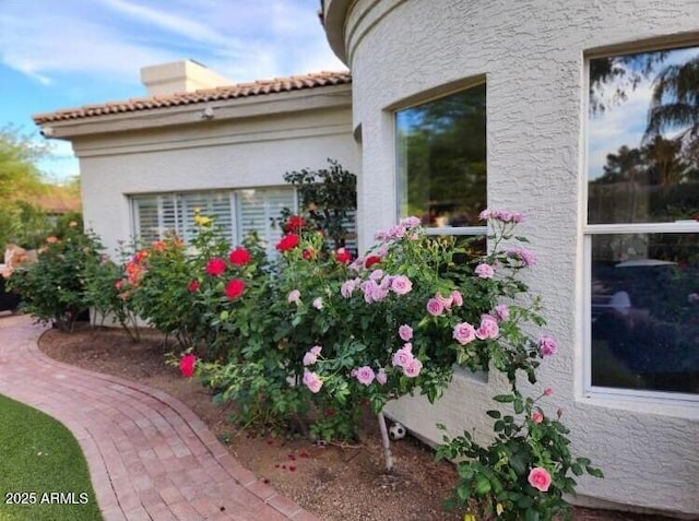 7214 E Royal Palm Rd, Scottsdale, AZ 85258 - view of side of property with a tiled roof, stucco siding, and a chimney