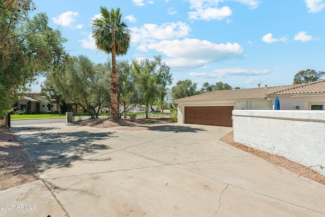 7214 E Royal Palm Rd, Scottsdale, AZ 85258 - view of home's exterior with concrete driveway, a tiled roof, a garage, and stucco siding