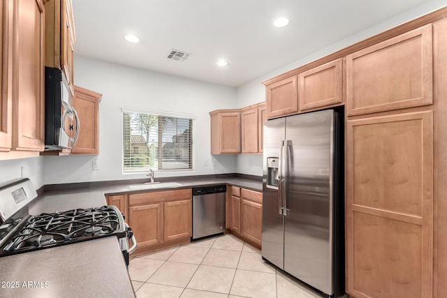 kitchen with sink, light tile patterned floors, and appliances with stainless steel finishes