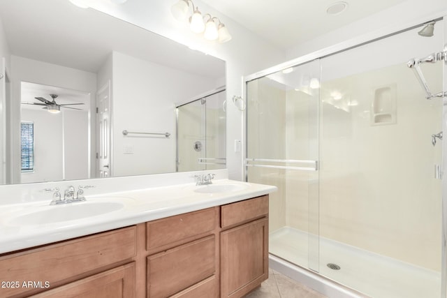 bathroom featuring a shower with door, vanity, tile patterned flooring, and ceiling fan