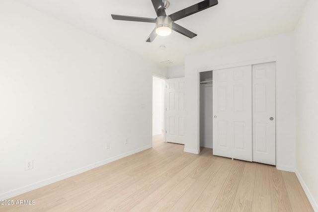 unfurnished bedroom featuring ceiling fan, light wood-type flooring, and a closet