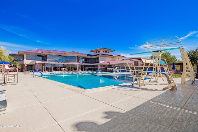 view of swimming pool featuring a playground and a patio area