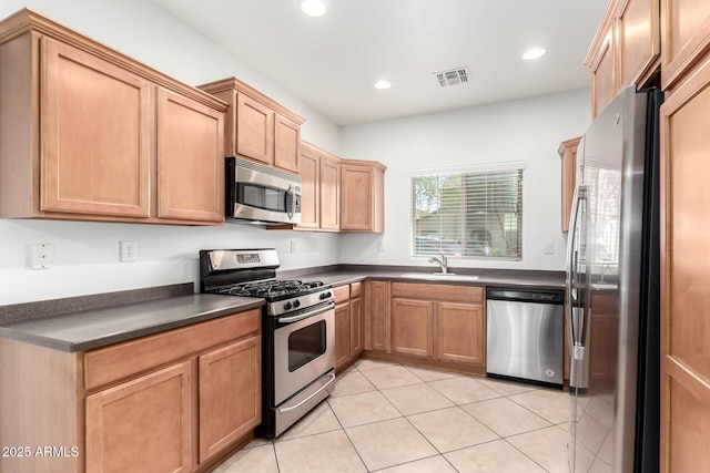 kitchen with appliances with stainless steel finishes, sink, and light tile patterned floors