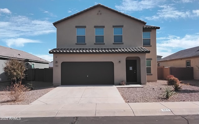 mediterranean / spanish home featuring driveway, an attached garage, fence, and stucco siding