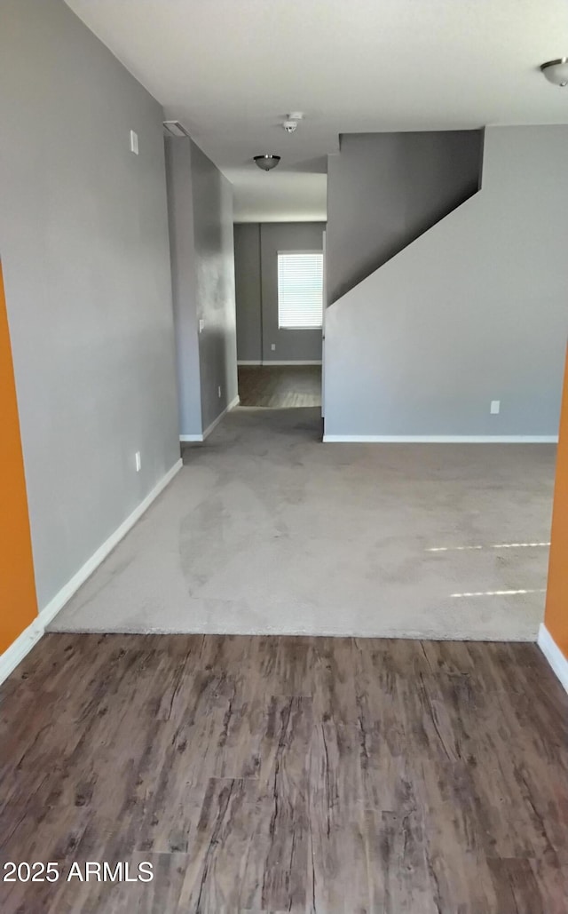 unfurnished room with baseboards and wood finished floors