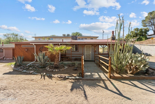 rear view of property with metal roof