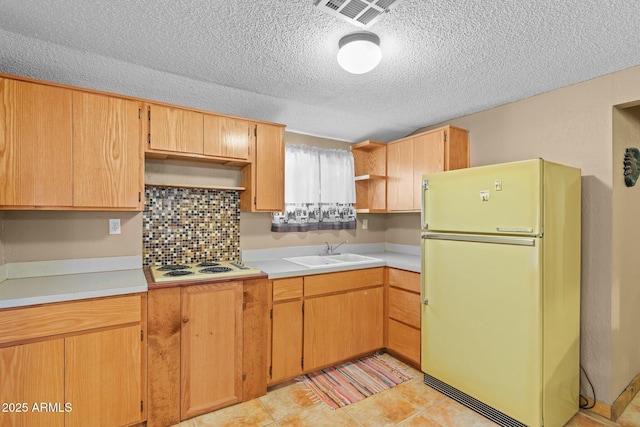 kitchen featuring white appliances, open shelves, a sink, visible vents, and a textured ceiling