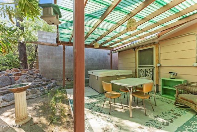 view of patio / terrace with outdoor dining area, a hot tub, and a pergola