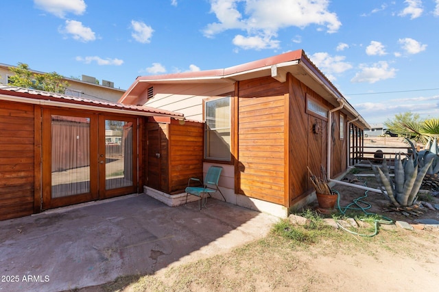 back of property featuring metal roof and a patio