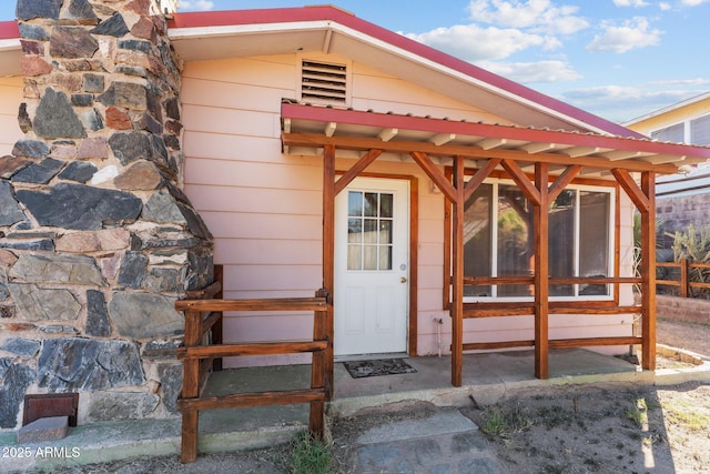 entrance to property featuring metal roof