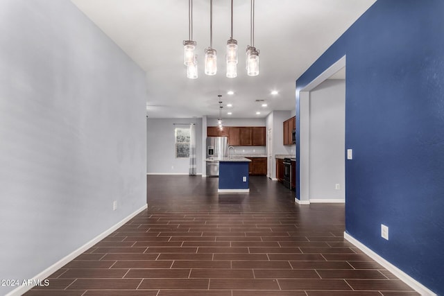 kitchen featuring sink, hanging light fixtures, dark hardwood / wood-style floors, appliances with stainless steel finishes, and a kitchen island