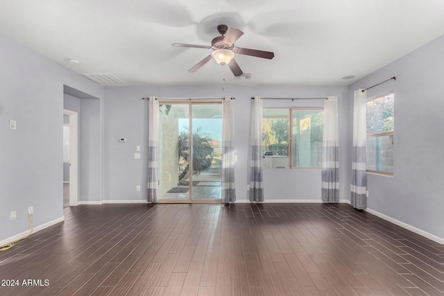 unfurnished room with dark wood-type flooring, ceiling fan, and a healthy amount of sunlight