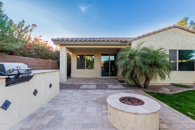 view of patio with a fire pit and a grill