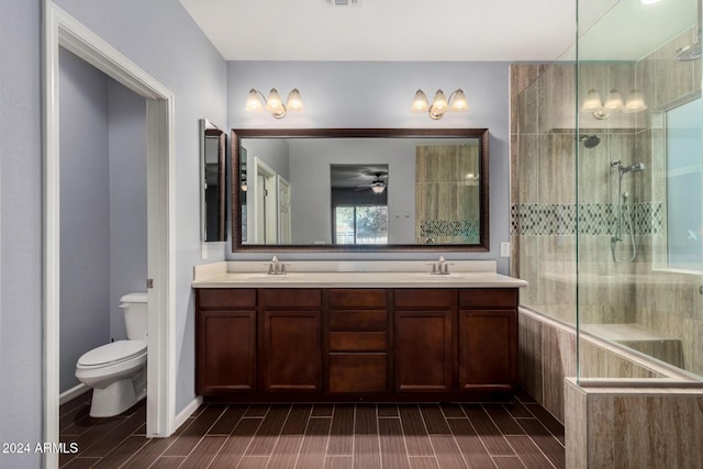 bathroom featuring a tile shower, vanity, and toilet