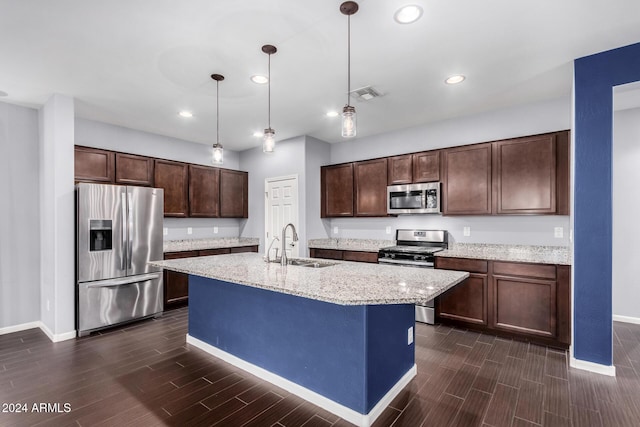 kitchen with pendant lighting, sink, dark brown cabinetry, and stainless steel appliances