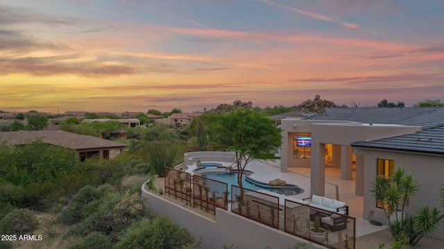 exterior space featuring a patio area, an in ground hot tub, and an outdoor pool