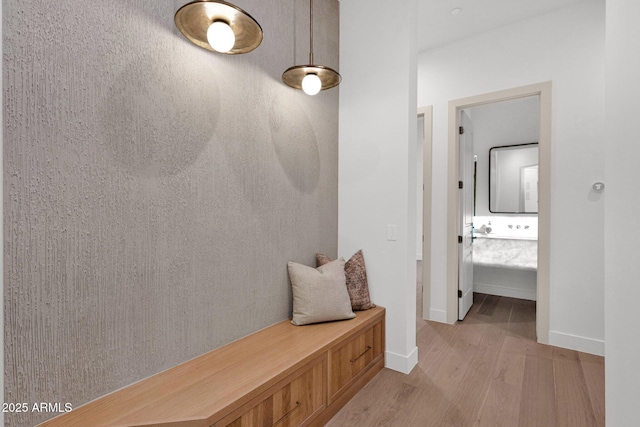 mudroom featuring light wood-style flooring and baseboards
