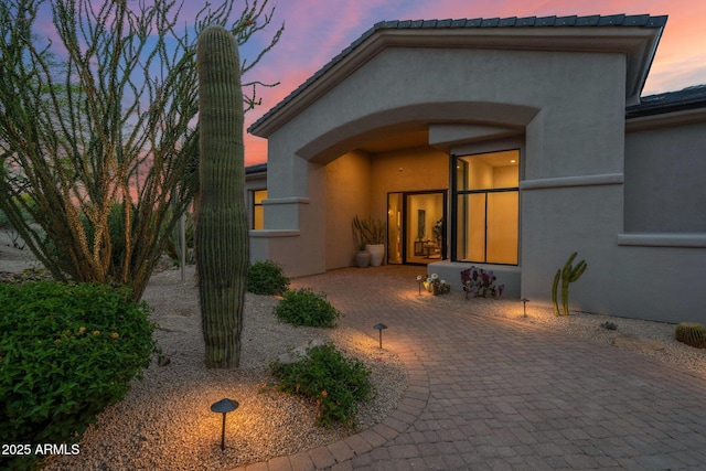 exterior entry at dusk with stucco siding