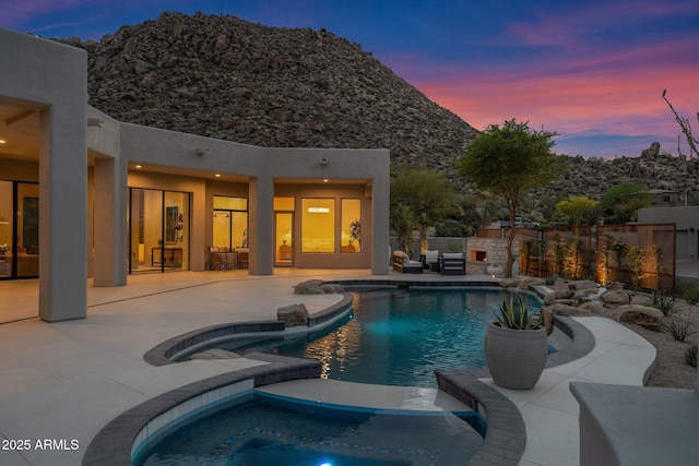 view of pool featuring fence, a patio area, a fenced in pool, and an in ground hot tub