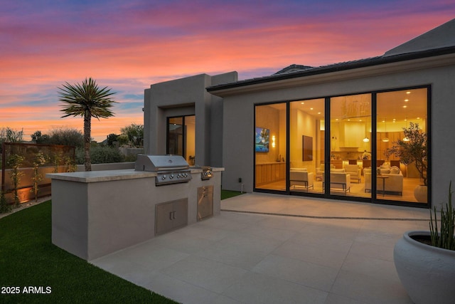 back of house featuring exterior kitchen, a patio area, stucco siding, and fence