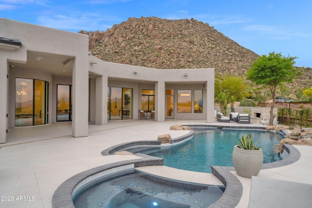 view of pool featuring an outdoor hangout area, a patio area, an in ground hot tub, a mountain view, and a fenced in pool
