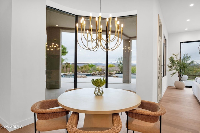 dining space featuring a chandelier, recessed lighting, light wood-style floors, and baseboards