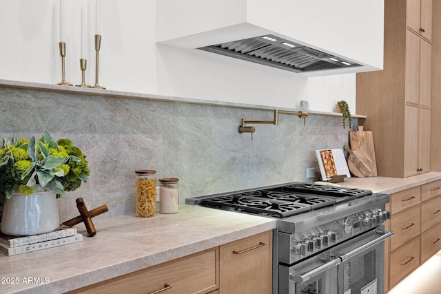 kitchen featuring light countertops, custom range hood, light brown cabinets, and range with two ovens