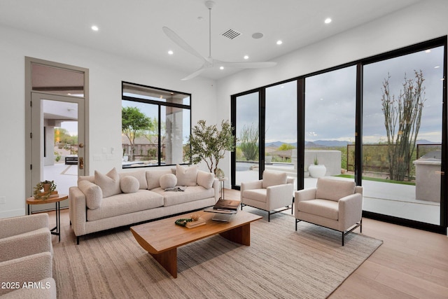 living room with visible vents, light wood-type flooring, and recessed lighting
