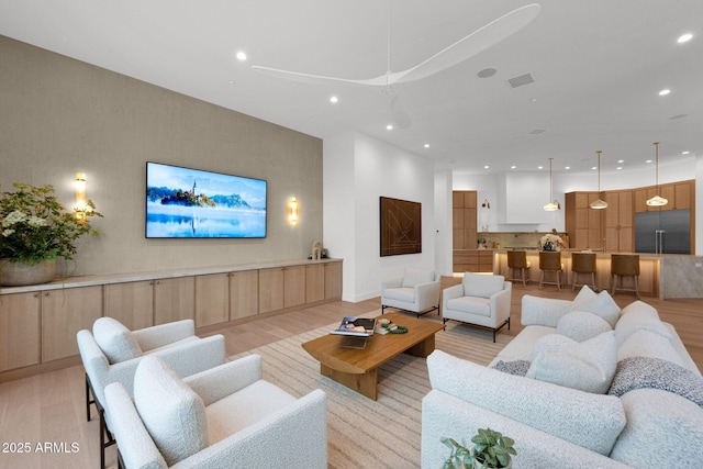 living area with recessed lighting, light wood finished floors, and visible vents