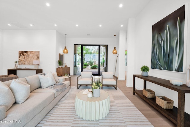 living area featuring light wood-type flooring, baseboards, visible vents, and recessed lighting