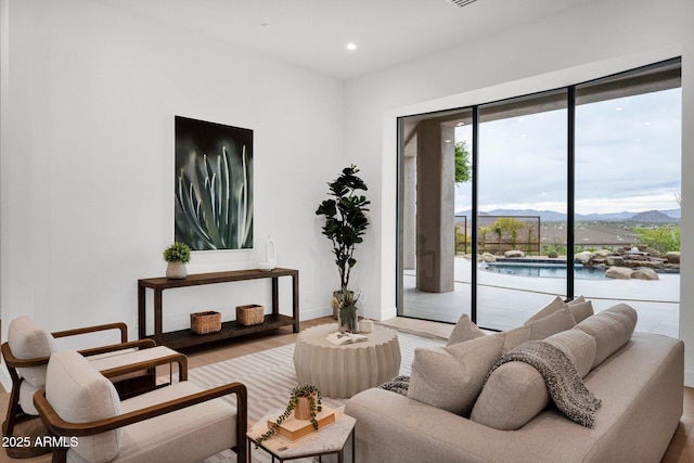 living area featuring wood finished floors, a mountain view, baseboards, and recessed lighting