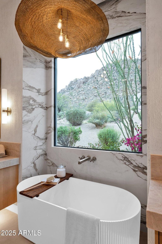 full bathroom featuring a healthy amount of sunlight and a soaking tub