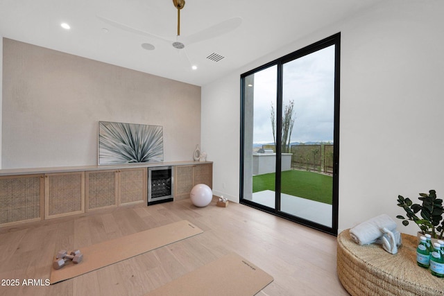 interior space featuring expansive windows, recessed lighting, visible vents, wine cooler, and wood finished floors