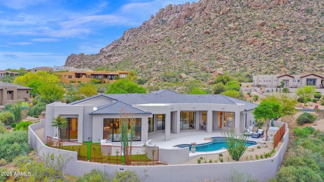 back of house featuring a fenced backyard, stucco siding, a patio, a tile roof, and a mountain view